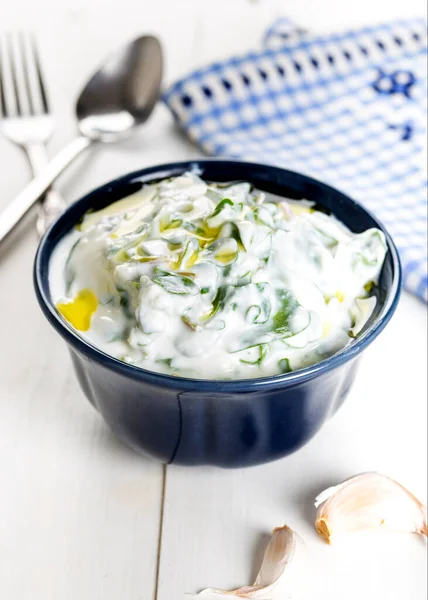 Purslane salad with yogurt in bowl on wooden background.