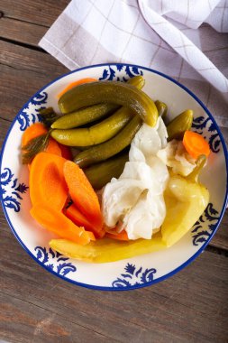 Doğal ahşap arka planda, kase / tabak içinde çeşitli sebzeler..