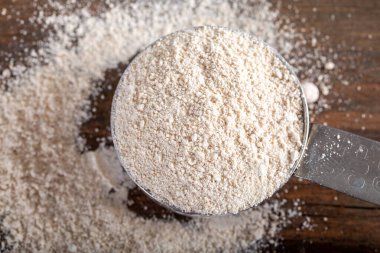 Einkorn Siyez doğal arka planda metal ölçü kabında tam buğday unu.