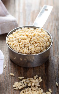 Metal bir kasede tam buğday irmiğinden yapılmış organik arpa eriştesi..