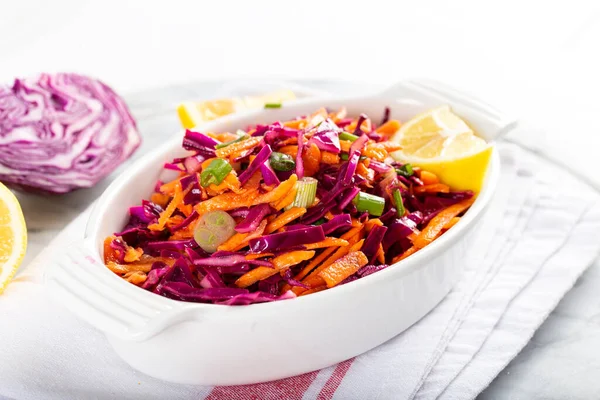 Kırmızı lahana ve yeşil soğanlı havuç salatası ve masada limonlu domates..