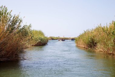 Dalyan, Mugla / Türkiye - 09 / 26 / 2020: Lycian kaya mezarlarının manzarası ve Türkiye 'deki Dalyan Nehri üzerinde turistlerle tekne gezileri.