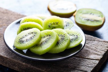 Kivi, beyaz siyah arka planda kaseyi dilimler.. 