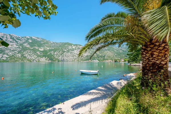 Lege promenade met uitzicht op de bergen. Boot op het water Montenegro Kotor baai Rechtenvrije Stockfoto's