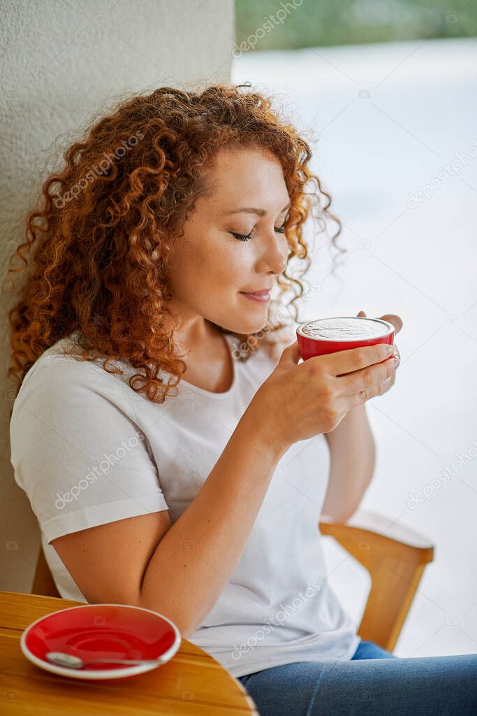 A young woman drinks coffee