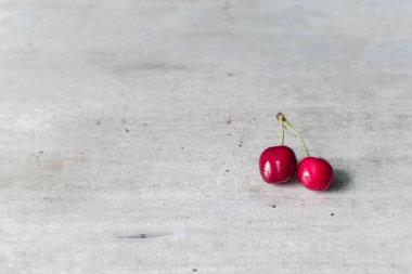 Açık arkaplanda kırmızı iki kiraz, üst görünümde