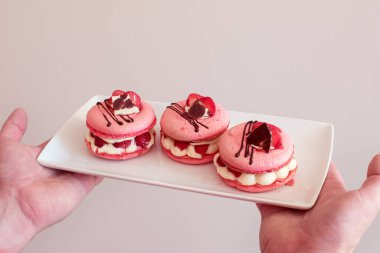 Krema ve çilekle doldurulmuş pembe badem kurabiyeleri. pastel renkler