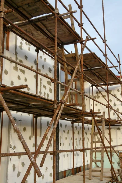 Thermal insulation of house wall with polystyrene. Picture of a scaffolding near familyhouse, contact thermal insulation system