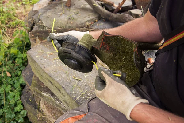 changing strings in a string trimmer, close-up view of a man\'s hands, close up