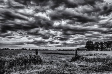 Siyah ve Beyaz HDR 'de bir barajın üzerinde çitle çevrili dramatik bir gökyüzü.