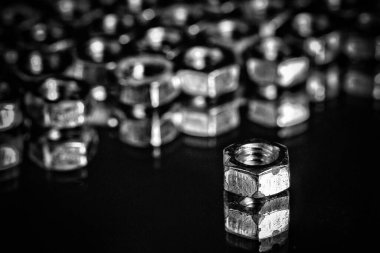 Siyah bir arkaplanda izole edilmiş gümüş renkli fındık (donanım) yığını