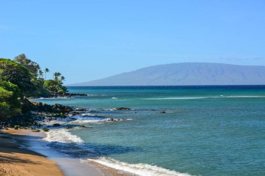 Kuzeybatı Maui 'deki güzel Kahana Sahili. Oteller ve apartmanlar su kenarında. Molokai ve Lanai adalarının muhteşem manzarası.