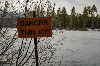 Thin ice warning sign on Manzanita Lake in Lassen Volcanic National Park in Northern  California, USA.   clipart