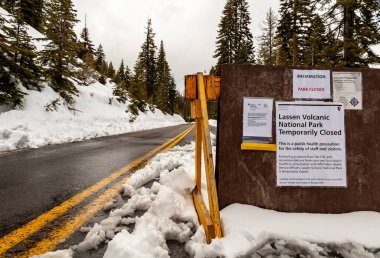 PLUMAS COUNTY, CALIFORNIA - Mart 31,2020 - işaretler ve barikatlar Lassen Volkanik Ulusal Parkı 'nın kapatılmasını ve COVID-19' un yeni Coronavirüs 'ü nedeniyle girişin engellenmesini bildirdiler.