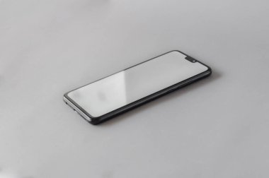 Gri arkaplanlı beyaz ekranlı cep telefonu