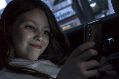 Küçük kız kısa mesaj okuyor.