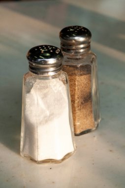 Containers with salt and pepper in restaurant in latin america, natural light. clipart