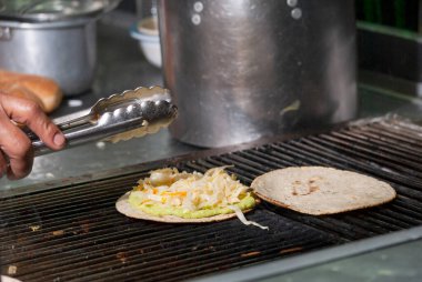 Kömürde kızartılmış mısır tortilla yanında sosis ve soslu et, Guatemala yemeği, MIXTA adında bir fast street food..