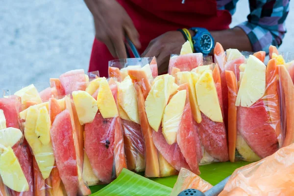 Sale of street fruit in the city of Guatemala in the morning, watermelon, pineapple, melon in small plastic bags.