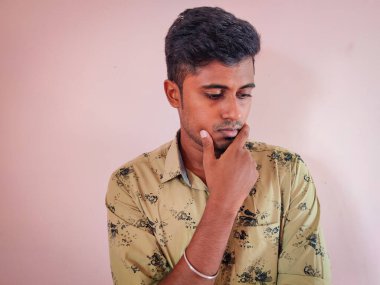 Suratı asık, temiz, Güney Hintli genç bir adamın portresi.