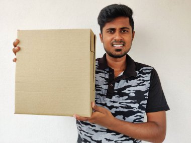 Elinde karton kutu tutan gülümseyen Güney Hintli adam. Uzayı kopyala Beyaz arka plan. Paket Konsepti