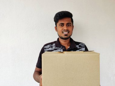 Elinde karton kutu tutan gülümseyen Güney Hintli adam. Uzayı kopyala Beyaz arka plan. Paket Konsepti