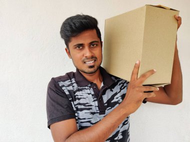 Elinde karton kutu tutan gülümseyen Güney Hintli adam. Uzayı kopyala Beyaz arka plan. Paket Konsepti