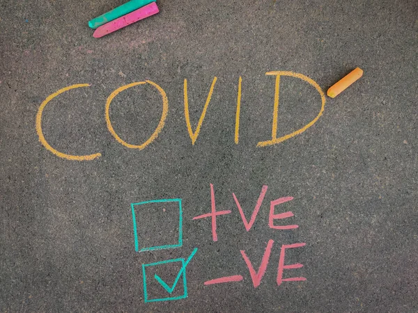 The inscription text on the grey board,Ticked box with negative test results for COVID .Using color chalk pieces. Corona virus concept