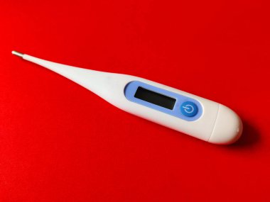 Sıcaklığı ölçmek için dijital termometre. Kırmızı arkaplanda izole.