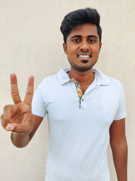 Beyaz Tişörtlü Iki Numaralı Parmaklarıyla Gülümseyen Güney Hintli Genç Adam — Stok fotoğraf