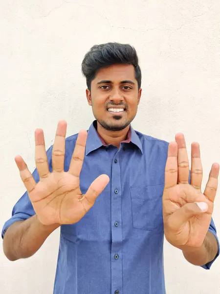 指の番号9を指して青いシャツを着て南インドの若い男の笑顔 白地に隔離された — ストック写真