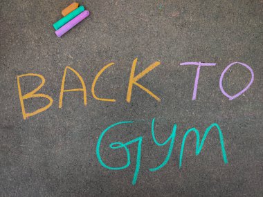 Gri tahtadaki yazı metni, GYM 'e geri döndü. Renkli tebeşir parçaları kullanarak. Korona sonrası konsept