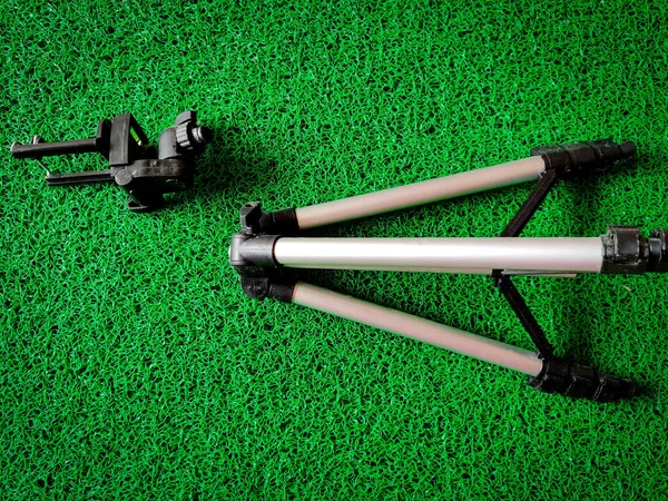 Kırık mobil tripod yeşil arka planda izole edildi. Üst görünüm