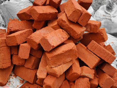 İnşaat alanında bir yığın kırmızı tuğla. Açık havada. Gün ışığı durumu
