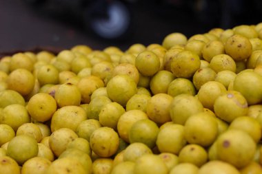 Pazarda bir sürü parlak sarı limon var.