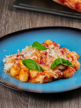 Fırında pişirilmiş gnocchi alla sorrentina, domates sosu, mozzarella ve yeşil taze fesleğen.