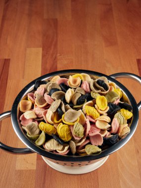 Pişmemiş siyah, kırmızı ve esmer pirinç gümüş kaşıklarda, ahşap bir tahtanın üzerinde 