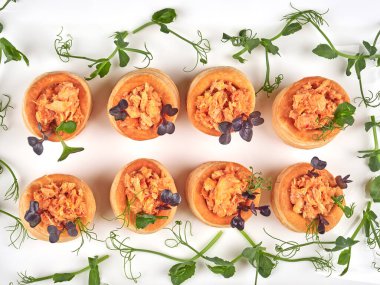 Baharatlı, tıknaz somon dolu, bezelye filizleriyle süslenmiş puf börekleri.       