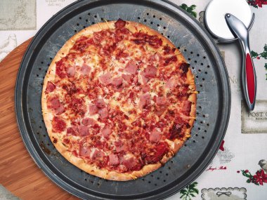 Paslı tepside jambonlu taze pişmiş pizza.