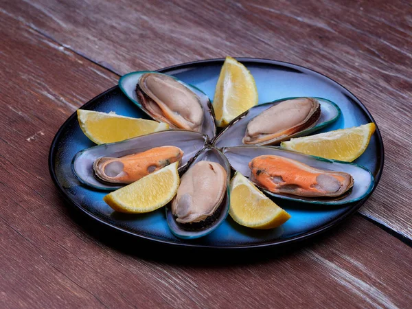 青板にセットされた新鮮なムール貝と本社レモン 暗い茶色の木製の表面に配置されます — ストック写真