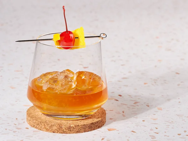 Old fashioned: a cocktail made by muddling sugar with bitters, then adding bourbon, and a twist of citrus rind
