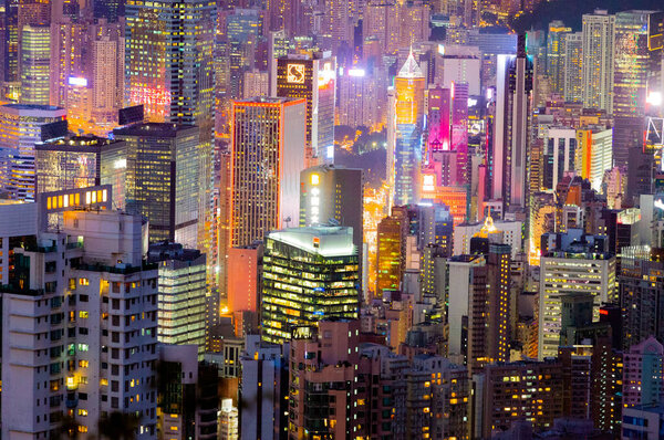 Victoria bay in Hong Kong from aerial view. Night city view. Neon lights. Modern city buildings.