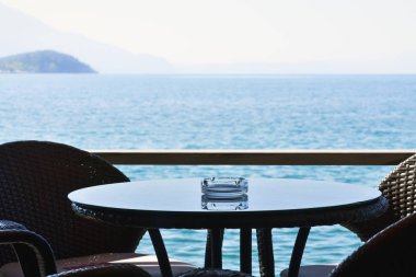 Yuvarlak masa ve sandalyeler denizin kenarında bir lokantada