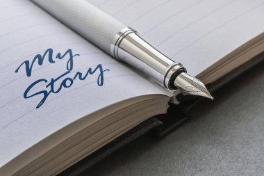 Fountain pen and text My Story written on an open notebook clipart