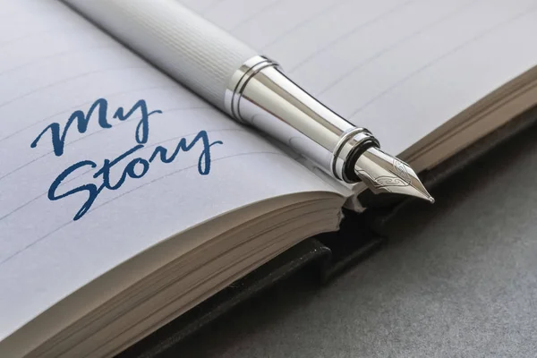Dolma kalem ve metin My hikaye bir açık defter üzerinde yazılı