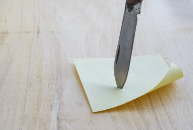 Etiket ve tahta zemin üzerinde küçük bir bıçak.