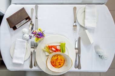 Her türlü detayı içeren iki restoran için bir masa hazırlandı ve içinde servis edilecek bir tabak yemek var.
