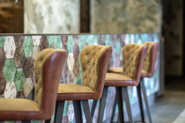 Bir bar tezgahının koltukları zarif bir şekilde lüks bir şekilde yerleştirilmiştir.