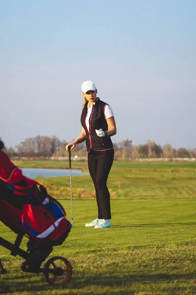 Jovem bela mulher está treinando golfe no outono — Fotografia de Stock