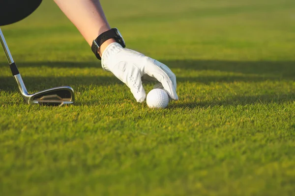 Mão feminina colocando bola de golfe no tee — Fotografia de Stock